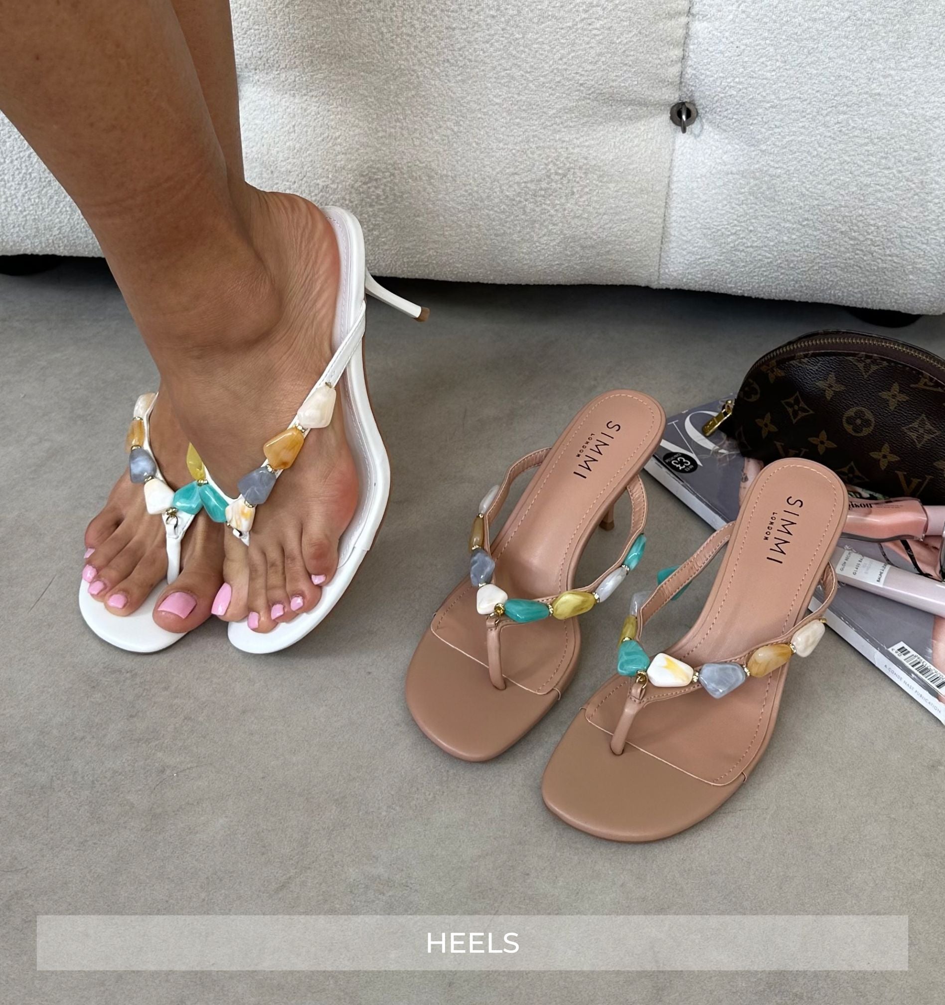 Pair of sandals with colorful beads on a gray surface.