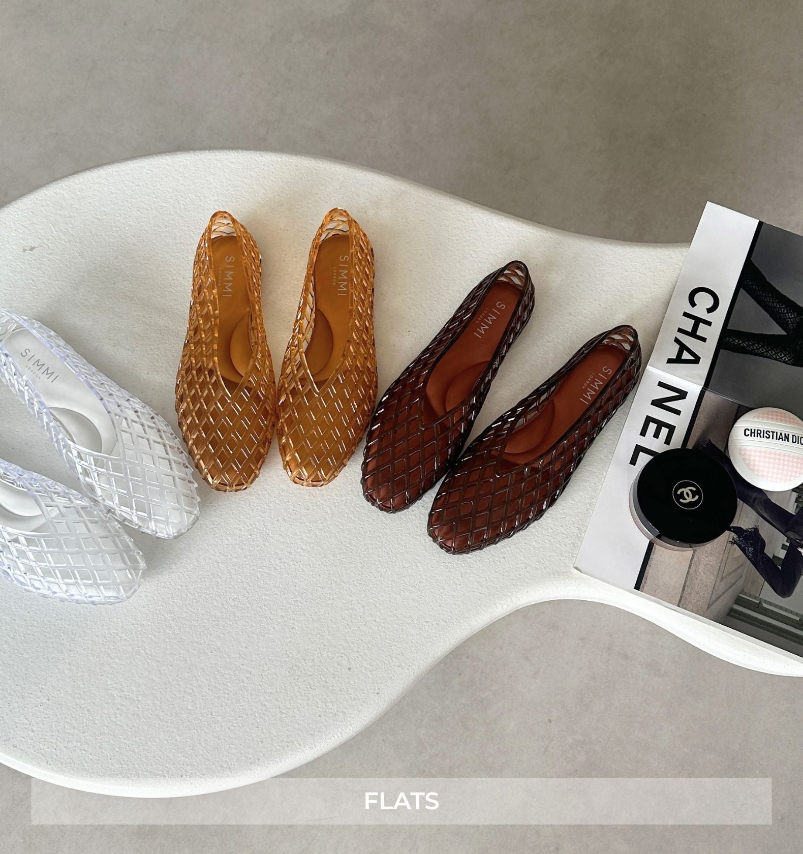 Pair of woven flats on a white surface with a Chanel magazine.