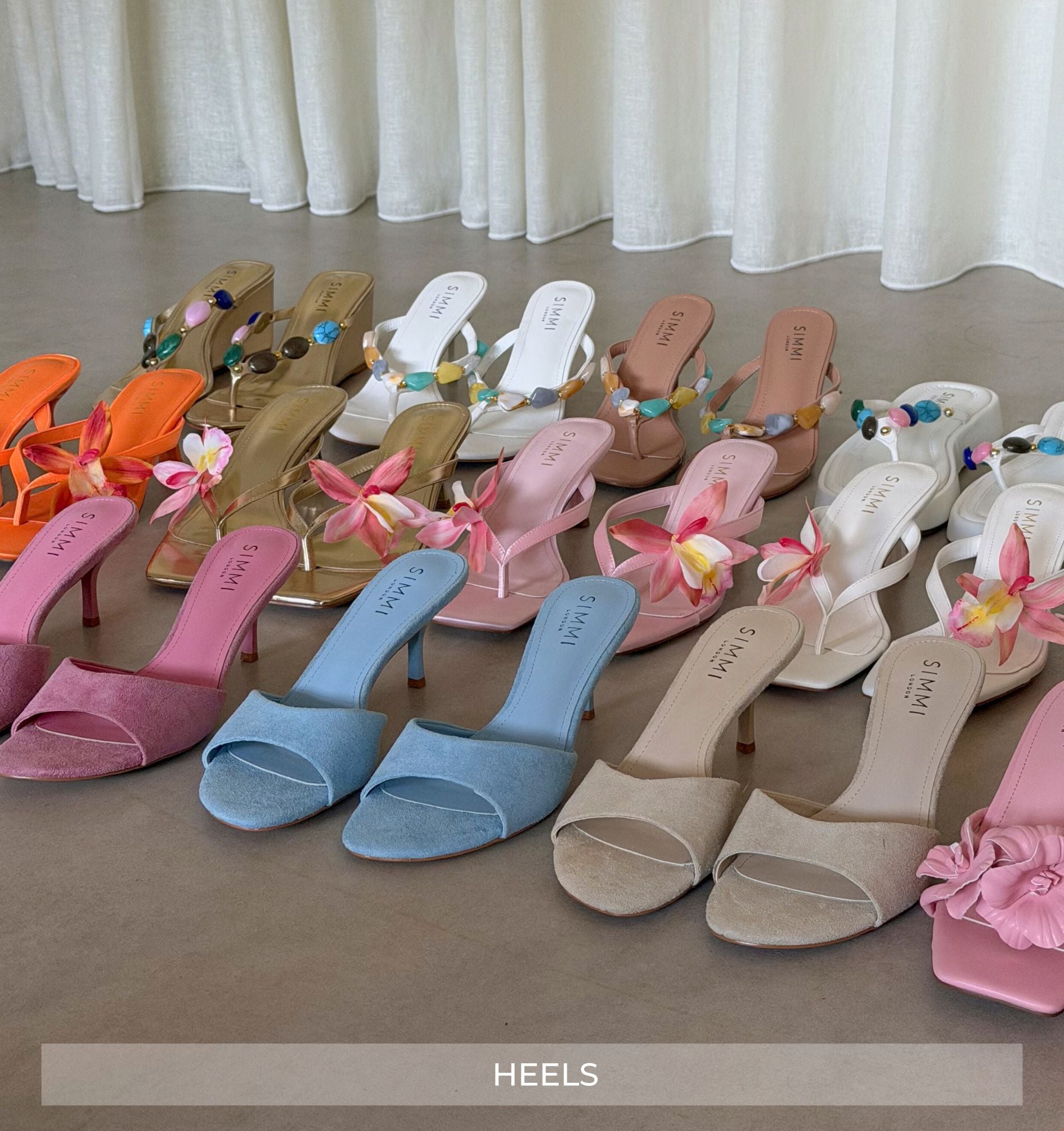 Colorful high-heeled shoes with floral decorations on a neutral background