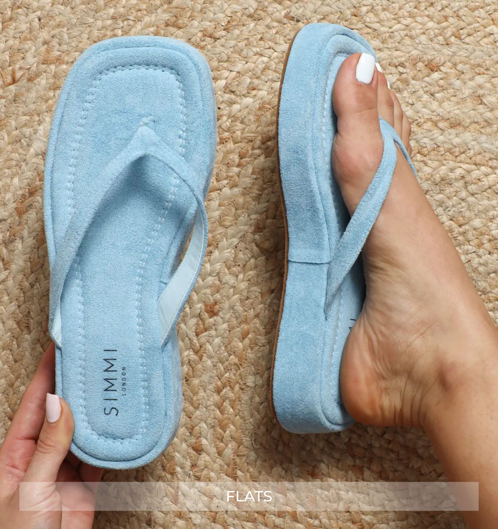 Light blue flip-flops worn on a textured beige carpet