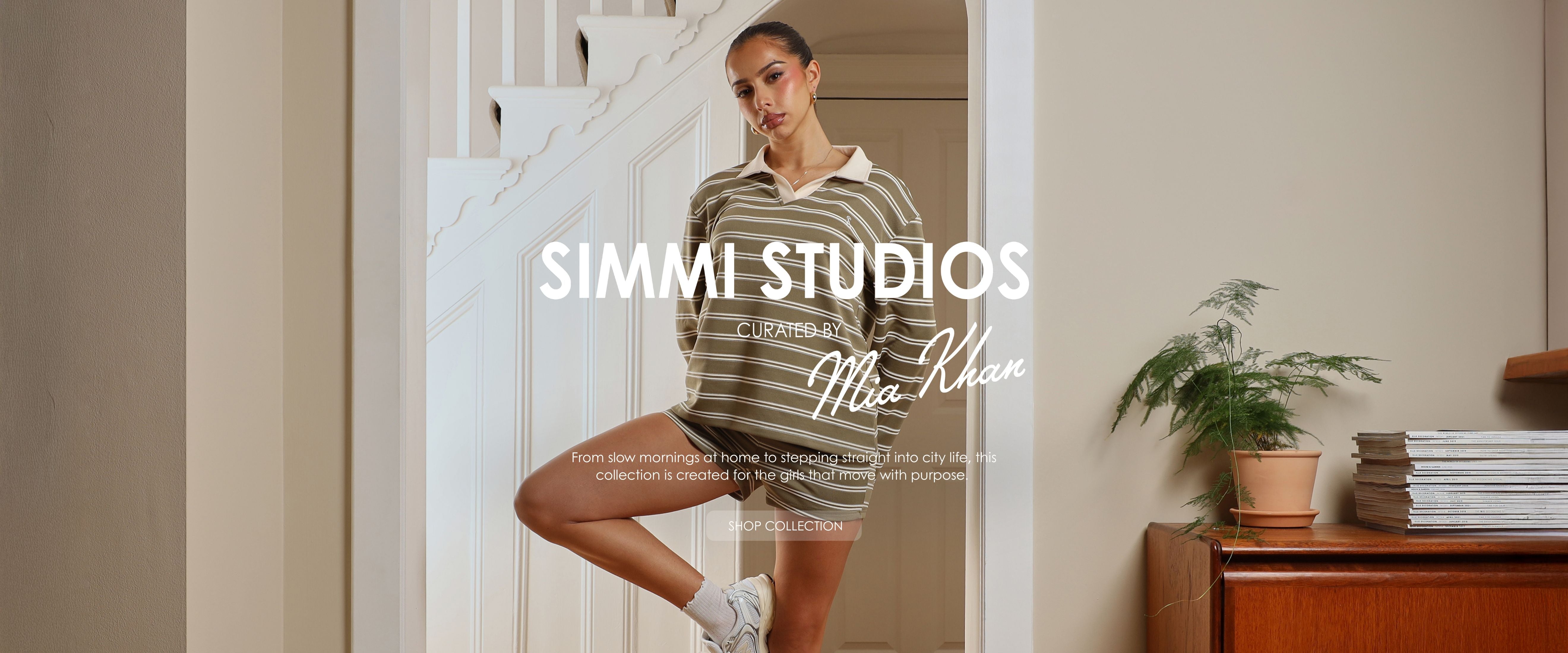 Woman in a striped sweater standing in a room with 'Simmi Studios' branding.