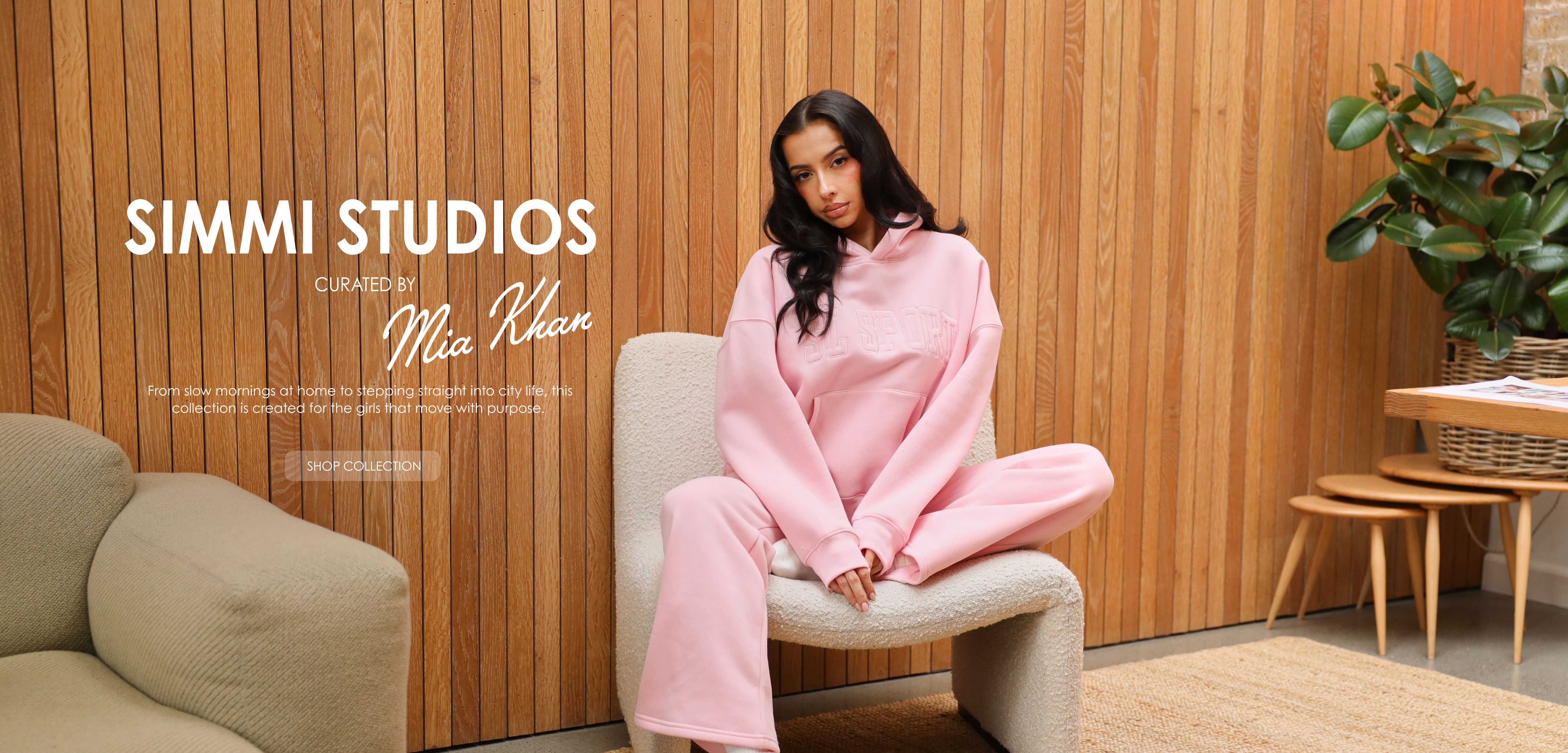 Woman in pink outfit sitting on a chair with 'Simmi Studios' branding.